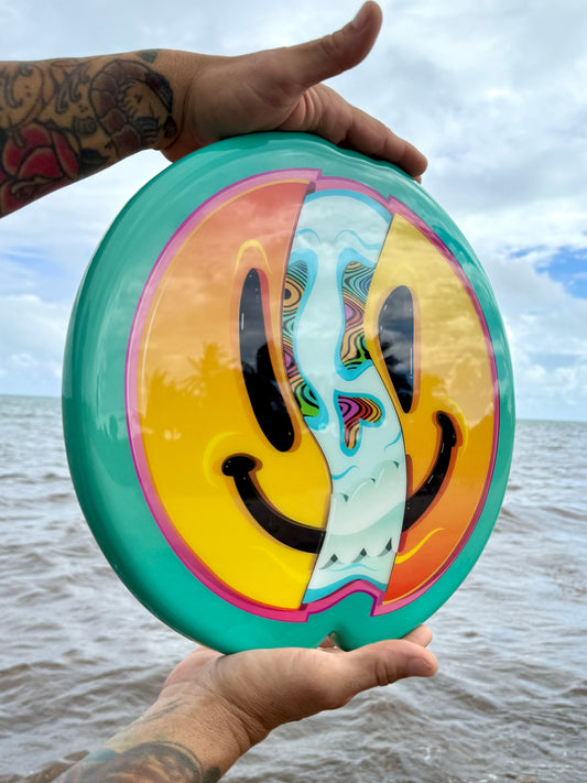 Colorful smiley face disc held by a person with a blurred background
